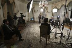Ο πρόεδρος του Ιράν, στο βάθος δεξιά, κατά τη διάρκεια της συνέντευξής του στην κρατική τηλεόραση. 